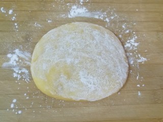 7、果干沙琪玛,饧发好的面团放在案板上压扁，两面抹上玉米淀粉防粘。