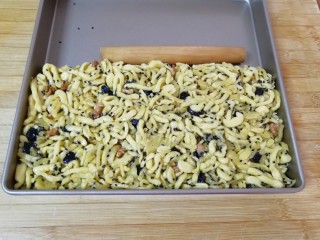 22、果干沙琪玛,炒好的面条盛入烤盘，用擀面杖压实。