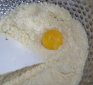 4、鬼脸南瓜塔,在搓揉一起的粉中挖个坑加入蛋黄,盐,将粉从四周往中间拨动