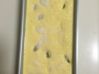 10、葡萄干戚风蛋糕,如图将拌匀的面糊倒入POP PAN模具,震几下排出气泡,表面再放些葡萄干、洒上椰丝;