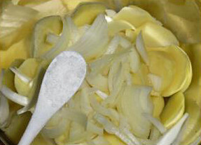 2、西班牙土豆饼,将洋葱和土豆放进大碗调入盐抖匀