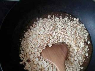 7、自制花生糖,然后把花生快速的倒到锅里面 关火 快速翻炒  把糖和花生伴匀