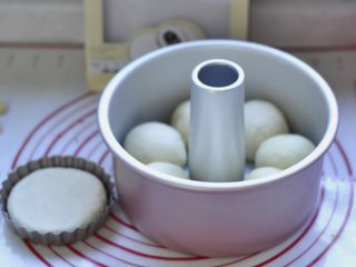 9、龙猫挤挤面包,将8个面团放入模具中，进行最后发酵。