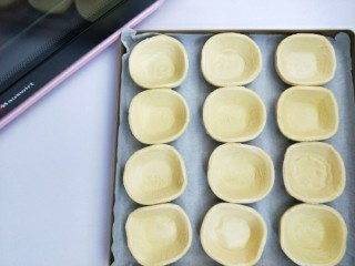 8、全蛋版蛋挞,蛋挞皮放入铺好油纸的烤盘。