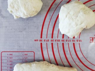 9、当主食一次可以吃三个的法棍面包,发酵至两倍大小，取出面团排气，分成三等份，依次擀成长舌状，卷起来。