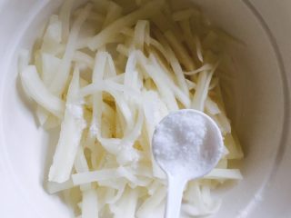 2、萝卜糕,放一勺盐到萝卜里,腌制20分钟出水