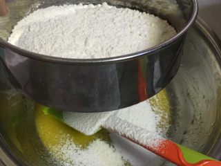 4、杯子蛋糕,拌好的蛋黄加入过筛面粉，切拌均匀，切记不可画圆圈以免面粉起筋。