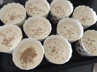8、杯子蛋糕,把拌好的蛋糕糊倒入杯子，七分满就可以了，撒上白芝麻