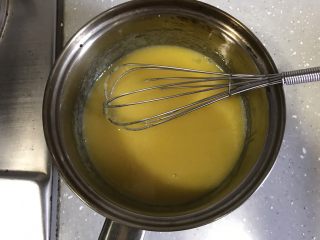12、芒果芭菲冰淇淋蛋糕,将牛奶、细砂糖和蛋黄放入奶锅搅拌均匀，开小火边加热边搅拌至浓稠状