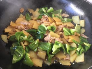 13、#圆土豆# 土豆肉片炒辣子,打开锅盖儿，放入辣子，翻炒均匀，使辣椒断生。