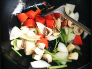 4、红酒炖牛肉,加入胡萝卜段，芹菜条，口蘑炒两三分钟，直到有些金黄变色。