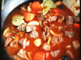 7、红酒炖牛肉,倒入红酒，煮开至粘稠状，加入开水淹没牛肉，加入香叶，百里香和少许海盐。