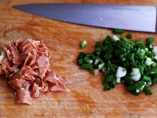 1、培根鸭蛋杂蔬炒饭,先把培根从冰箱拿出来解冻后用刀切成小块,小香葱去皮洗净后用刀切成碎末备用;