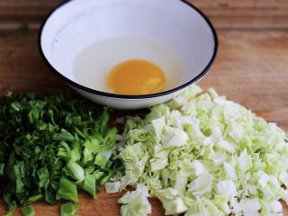 2、培根鸭蛋杂蔬炒饭,把一个鸭蛋打散在碗里,用筷子搅拌均匀,把莴苣叶和包菜用刀切成小块状备用;