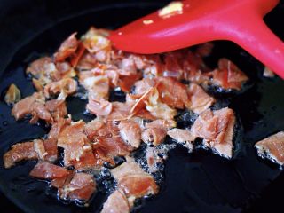 5、培根鸭蛋杂蔬炒饭,这个时候再重新另起锅烧热后,加入剩下的30克花生油烧热后,把切好的培根小丁放到锅里进行翻炒片刻;