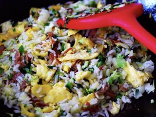 13、培根鸭蛋杂蔬炒饭,把加入锅里的鸭蛋打成小块状后,继续和所有的食材翻炒2、3分钟后就可以关火了;