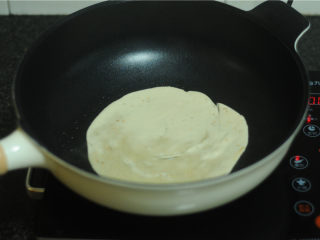 8、烤肉酱香饼,平底锅倒入适量油，将饼放入锅里，慢慢转动饼，中火煎至变色