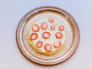 10、千层蛋糕,取一片面皮挤上奶油,摆放切片的草莓(挤奶油可以用裱花袋,或是用保鲜袋切一个0.3cm左右的小口当作裱花袋)(我不太习惯用抹刀操作,个人觉得保鲜袋或是裱花袋更好操作)