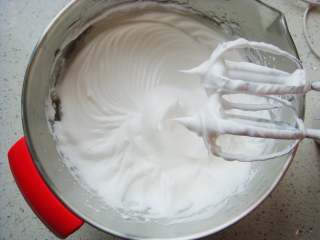 11、红柚果粒蛋糕,打发几圈后再次加入。最后一次加入剩余的白砂糖，继续高速打发。提起打蛋器观察蛋白状态：呈现完全直立的尖尖的角就好了。