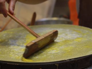 11、美味早餐 妈妈味道的绿豆煎饼果子,把鸡蛋均匀的摊在煎饼上。