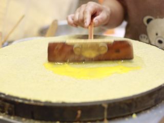 10、美味早餐 妈妈味道的绿豆煎饼果子,用竹蜻蜓将鸡蛋敲散。