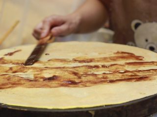 13、美味早餐 妈妈味道的绿豆煎饼果子,将煎饼翻过来，抹上少许的甜面酱、腐肉汁、辣椒酱。