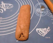 4、巧克力土司,左右三分之一处分别折过来,翻面擀长。再翻回来