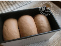 5、巧克力土司,再铺上一些巧克力豆,卷起,排入土司盒内最后发酵至8分满