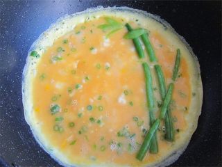 9、熊猫趣味早餐饼,蛋液半凝固状态时候，放入四季豆做竹子，叶子用四季豆剪成形状贴在上面