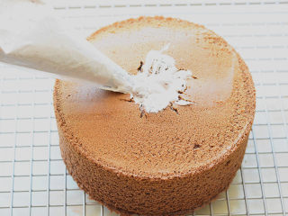 17、脏脏蛋糕,把泡芙嘴插进扣好的蛋糕里,往里面挤奶油,要转着圈挤,这个过程要用力,这样挤奶油才会充分填进蛋糕里面