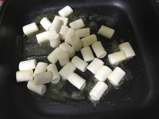 3、花生牛轧糖,倒入棉花糖一起搅拌，带棉花糖融化，倒入奶粉，搅拌均匀，再加入花生粒。（花生米提前炒熟，去掉红衣）