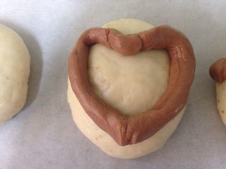 13、椰香萌猴面包（超详细做法）,把细长条放在白面团上，整理出一个爱心形。