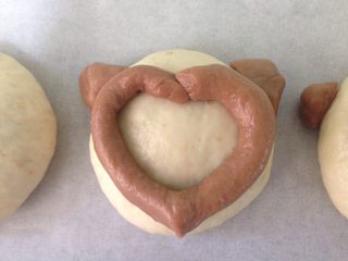 14、椰香萌猴面包（超详细做法）,把剩下的可可面团捏圆放在白面团两边当耳朵。