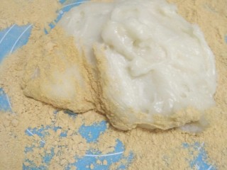7、驴打滚,蒸好的糯米团放在撒了豆面的案板上。