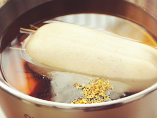 4、桂花糯米藕,放入大同外锅加入800ml的水，红糖还有少许桂花，按下开关，煮3小时左右，直到藕变得软糯