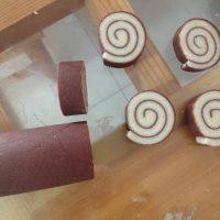 11、黑纹奶酪饼干,将面皮的一头向另一头紧紧卷起,放入冰箱冷冻室半个小时左右,再切成均匀厚度的片。