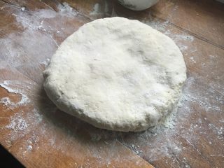 4、烙饼,将面团放在展板上，加面粉用擀面杖擀开。