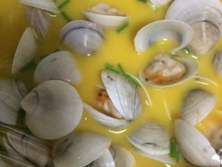 4、蛤蜊炖蛋,如图将蛤蜊均匀地码放进蛋液中，碗口用保鲜膜封住；