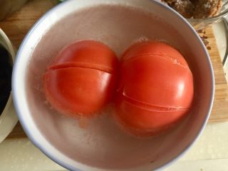 2、五色食蔬➕娃娃菜木耳粉丝藕丸汤,番茄清洗，表面划十字刀，放入碗中加入开水烫两三分钟，撕去表皮，不介意吃番茄皮的宝宝们也可以省略这步