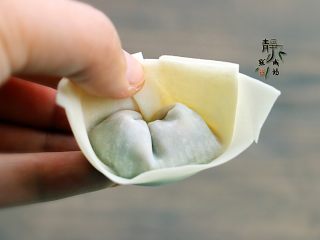 9、鲜肉荠菜馄饨,拿起馄饨,两边向中间靠拢并把接口重叠,捏紧,如图。如果馄饨皮发干,可以粘一点点清水就好包了。