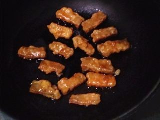 10、琥珀琉璃肉,将裹上糖稀的琉璃肉，一块一块地拣至刷过油容器中