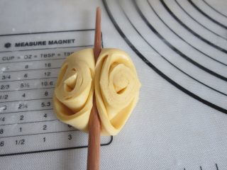 11、花样南瓜馒头,将三角尖朝上用筷子在上中按压一下，花形就出来了。