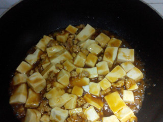 6、肉末豆腐,下入豆腐，晃动炒勺，使汤汁均匀的包裹在豆腐上，盛出装盘，撒上香菜段即可