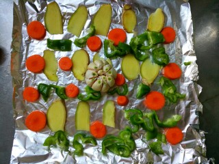 5、家有烤箱--迷迭香烤羊排,将青椒，大蒜头，胡萝卜，生姜铺好