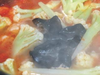 5、上汤有机花菜,然后放入有机花菜和泡发好的黑木耳再次煮开.撒上葱末即可