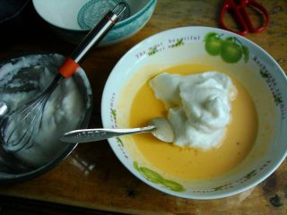 8、夹心水果派-健康蒸蛋糕,把一半打发的蛋清加入搅拌好的蛋黄液中，用勺子上下的搅拌，不能画圈拌。拌匀以后再放另一半，拌匀