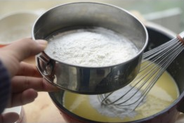 3、酸奶蛋糕,将低筋面粉与玉米淀粉混合筛入蛋黄糊中。