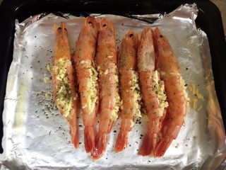 8、芝士焗大虾,表面撒上欧芹和黑胡椒。黑胡椒是一定要的。欧芹就看个人了。我自己很喜欢所以放的比较狠。如果你不喜欢可以选择不放。因为不够吃所以我后面又加了只。还放了红绿椒。