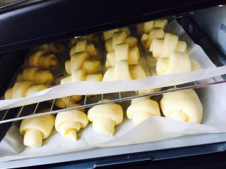 11、黄油牛角包,烤盘铺油纸摆放均匀放烤箱35度发酵一小时