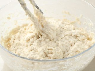 2、北方葱油千层饼,再用温水拌剩下的面粉，最后拌成比较黏的面团；